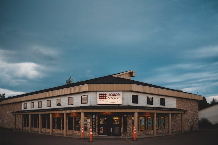 Facade Of Modern Liquor Store Under Blue Cloudy Sky