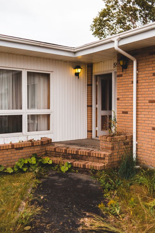 Free Contemporary dwelling building facade with brick wall and shiny lantern near pathway and stairs Stock Photo