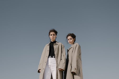 Free Two Women Wearing Beige Trench Coat Standing Next to Each Other Stock Photo