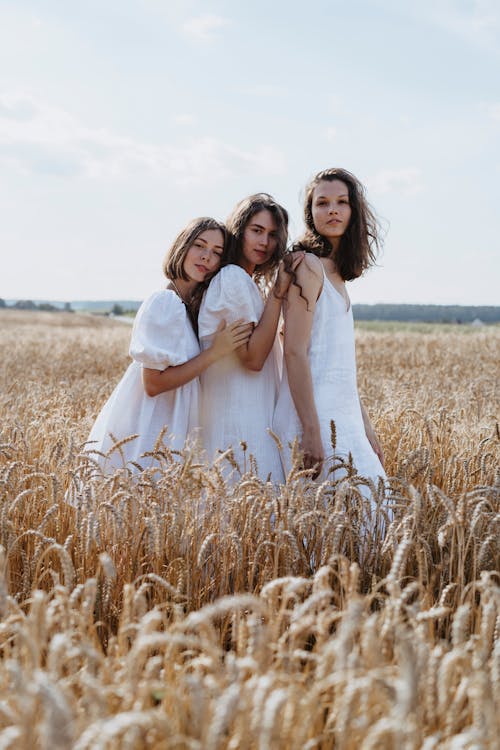 Three Women Standing Close Together in a Wheat Field