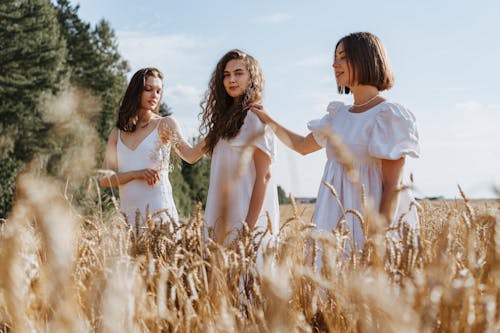 2 Women in White Dress Standing on Brown Grass Field