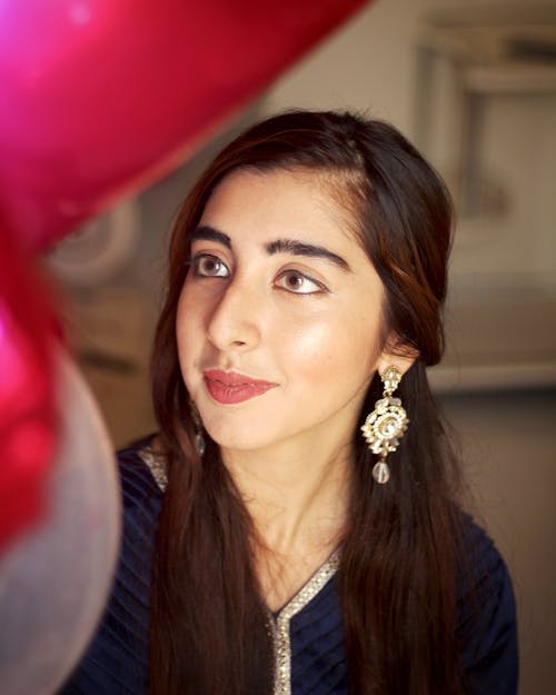 Woman in Blue Denim Jacket Wearing Gold and Diamond Studded Earrings