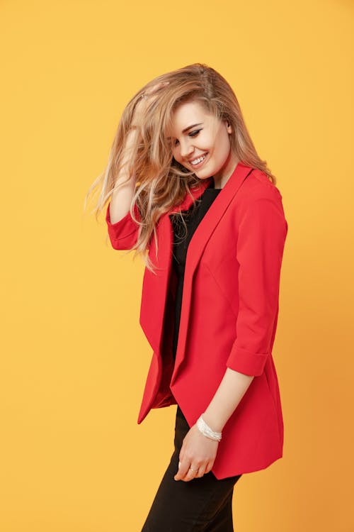 Cheerful woman touching hair and smiling