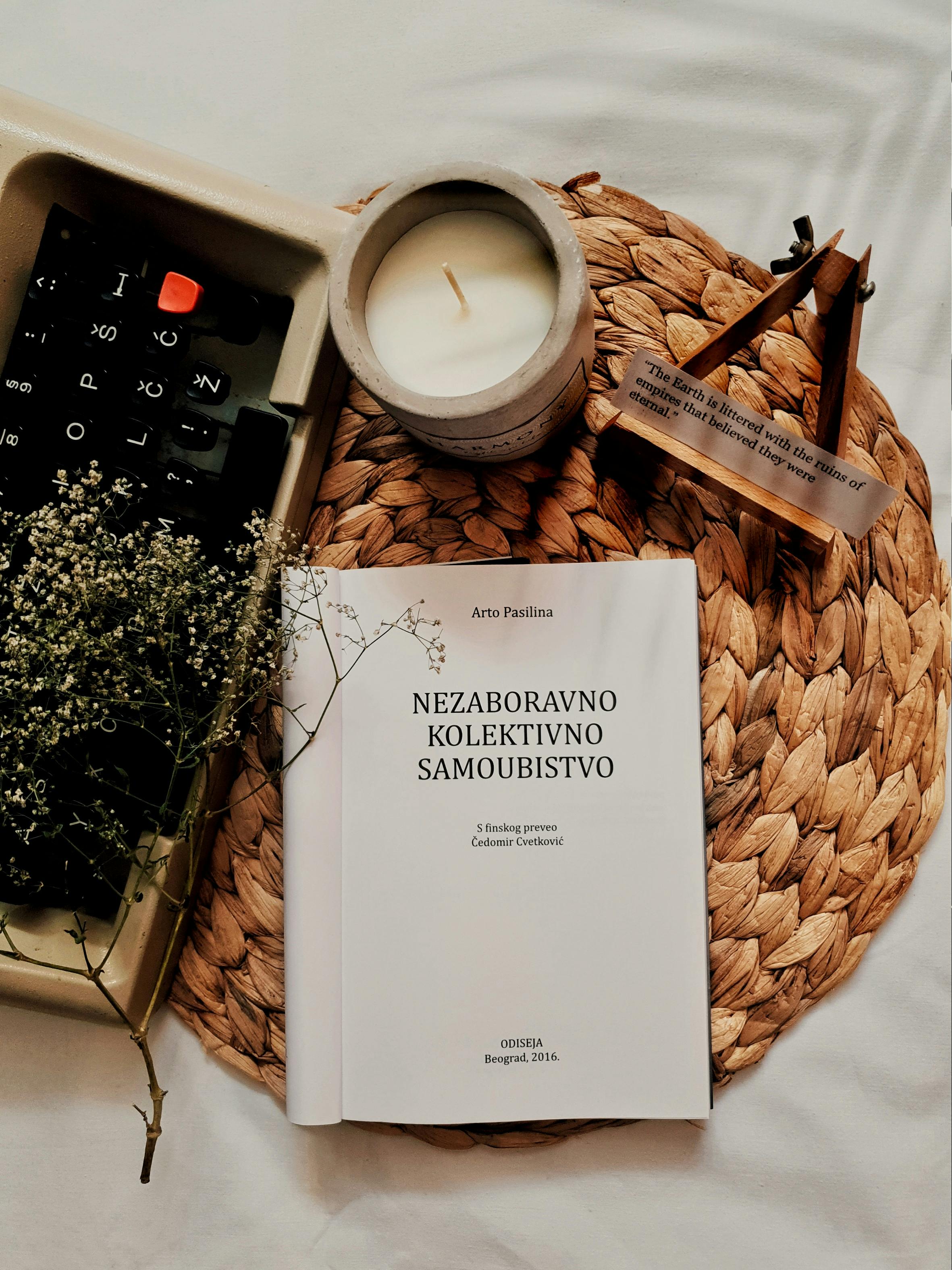 Cozy still life with a book, candle, and rustic decor elements.