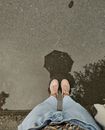 Person in Blue Denim Jeans and Brown Shoes Standing on Black and White Floor
