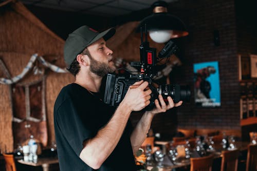 Free A Bearded Man Wearing Black Shirt while Filming Stock Photo
