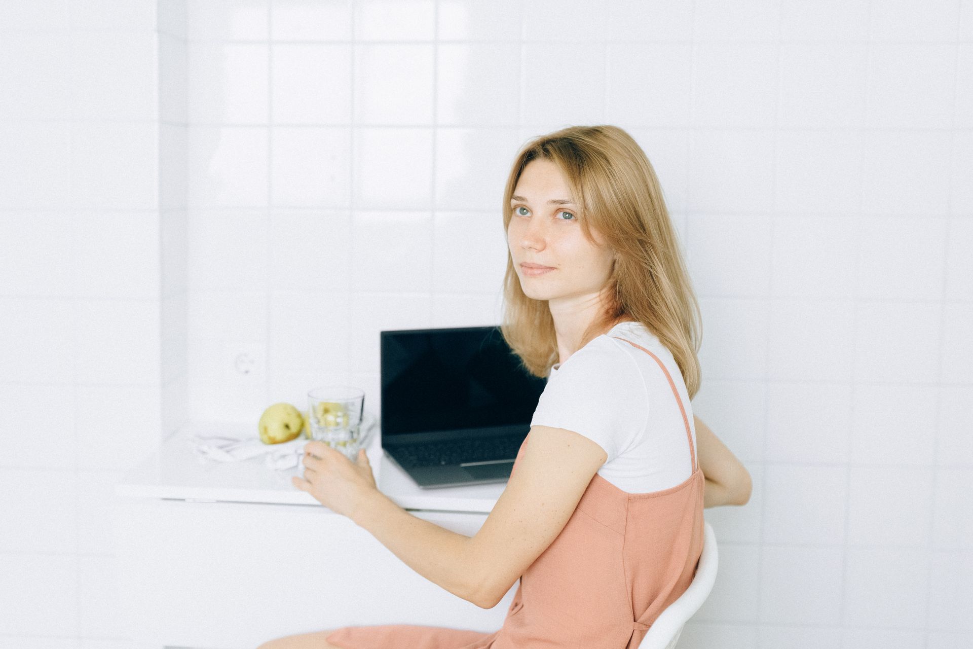 A woman works from home using a laptop, reflecting a modern lifestyle.