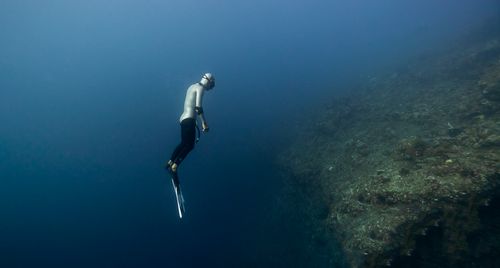 Free A scuba diver explores the depths of a coral reef in Bali, capturing the underwater beauty. Stock Photo