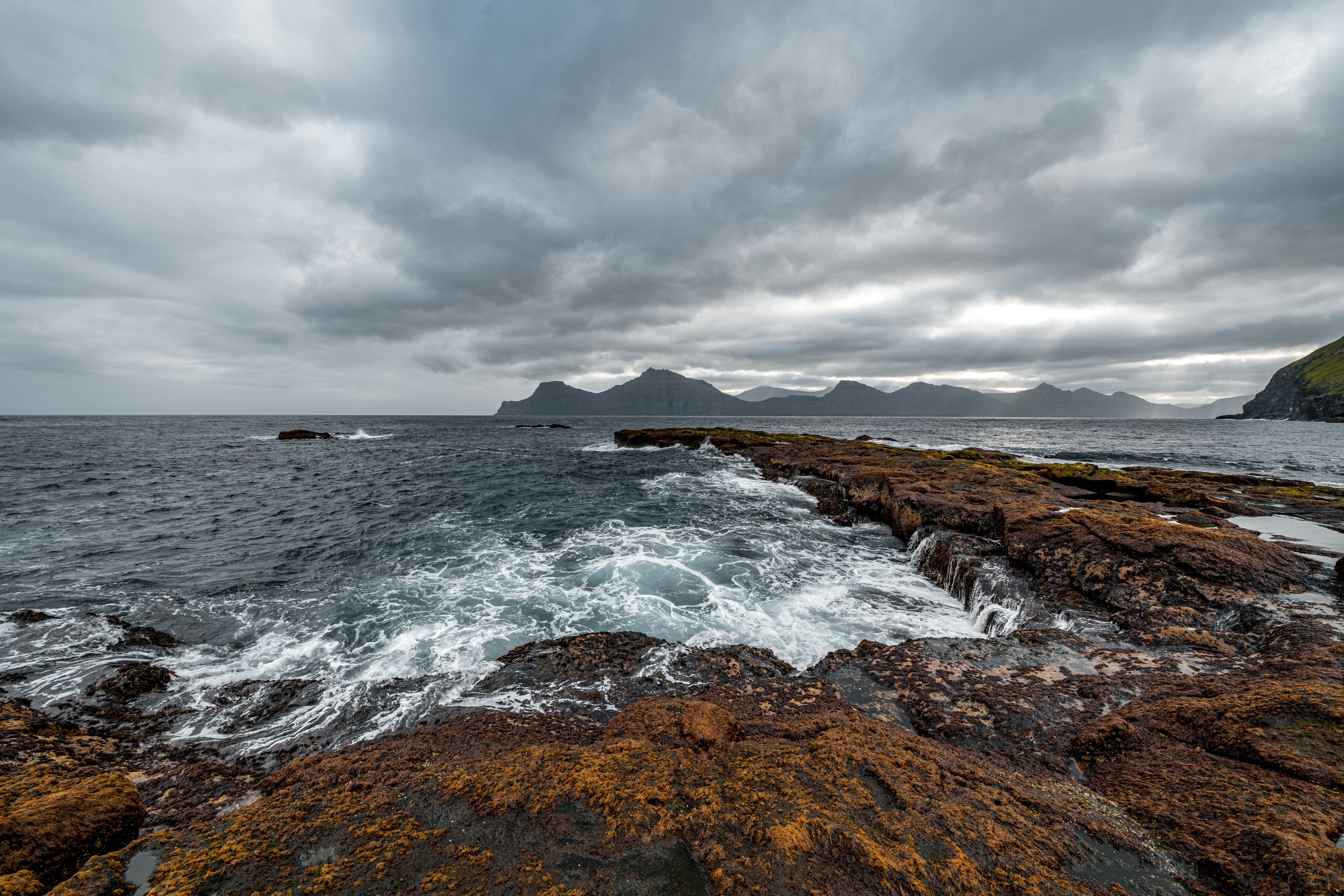 Brown Rocky Shore Under Cloudy Sky · Free Stock Photo