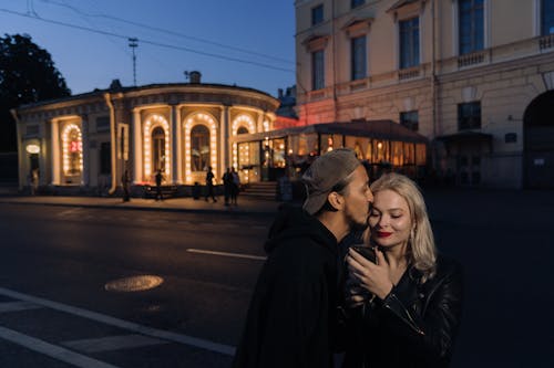 Man in Black Hoodie Kissing a Woman