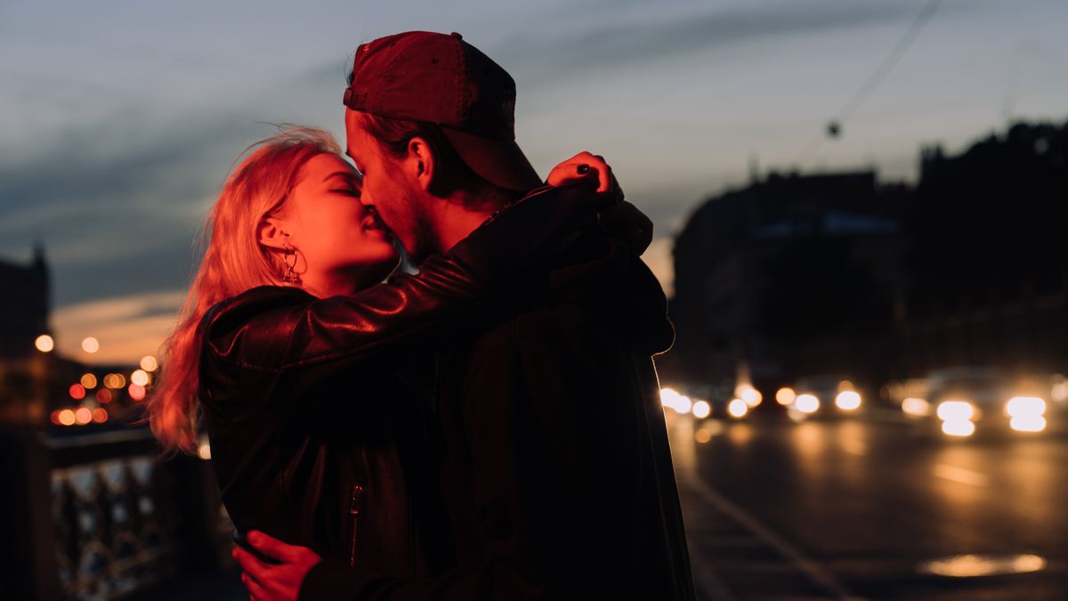 夕暮れの街でキスをするカップル(イメージ)