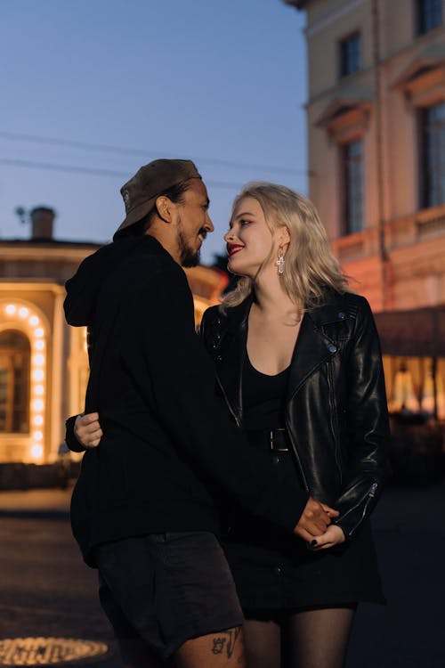 Free Woman in Black Leather Jacket Holding the Hand of a Man Stock Photo