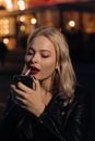 Woman in Black Leather Jacket Holding Black Smartphone