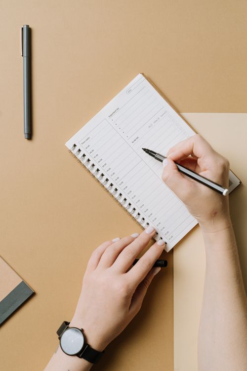 Woman Writing in a Planner ยท Free Stock Photo
