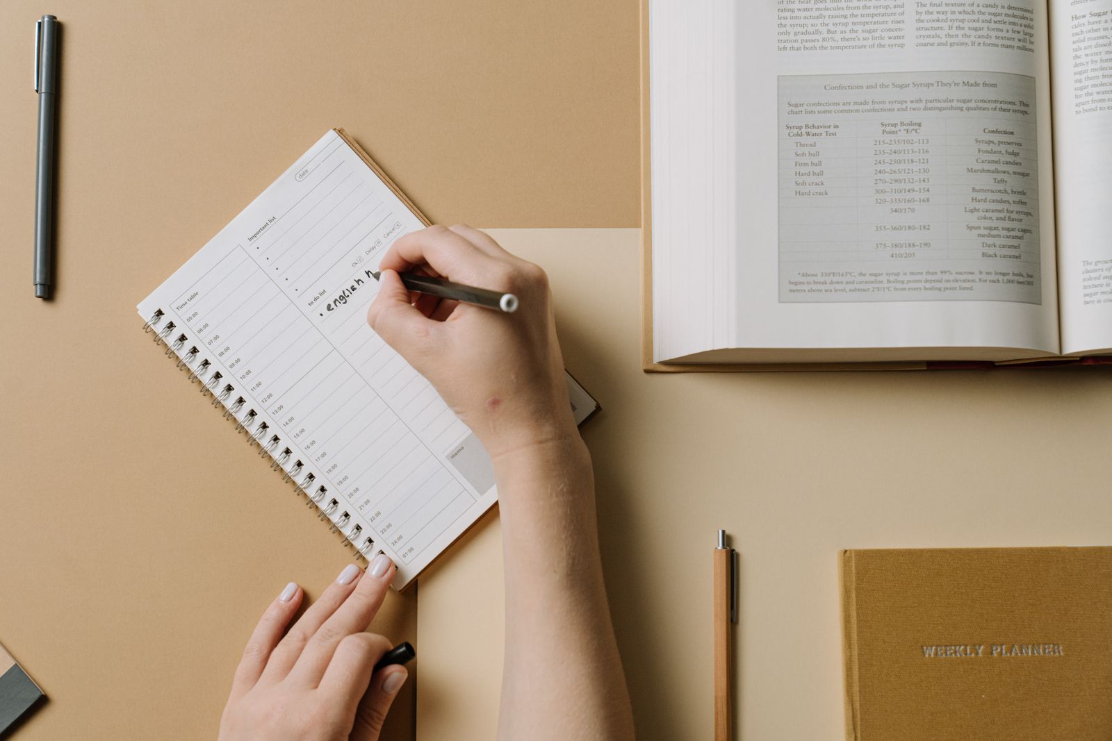 Person writing in a workout journal to track weekly exercise frequency