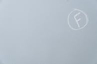An F Mark in a Circle Drawn with Chalk on Light Blue Surface