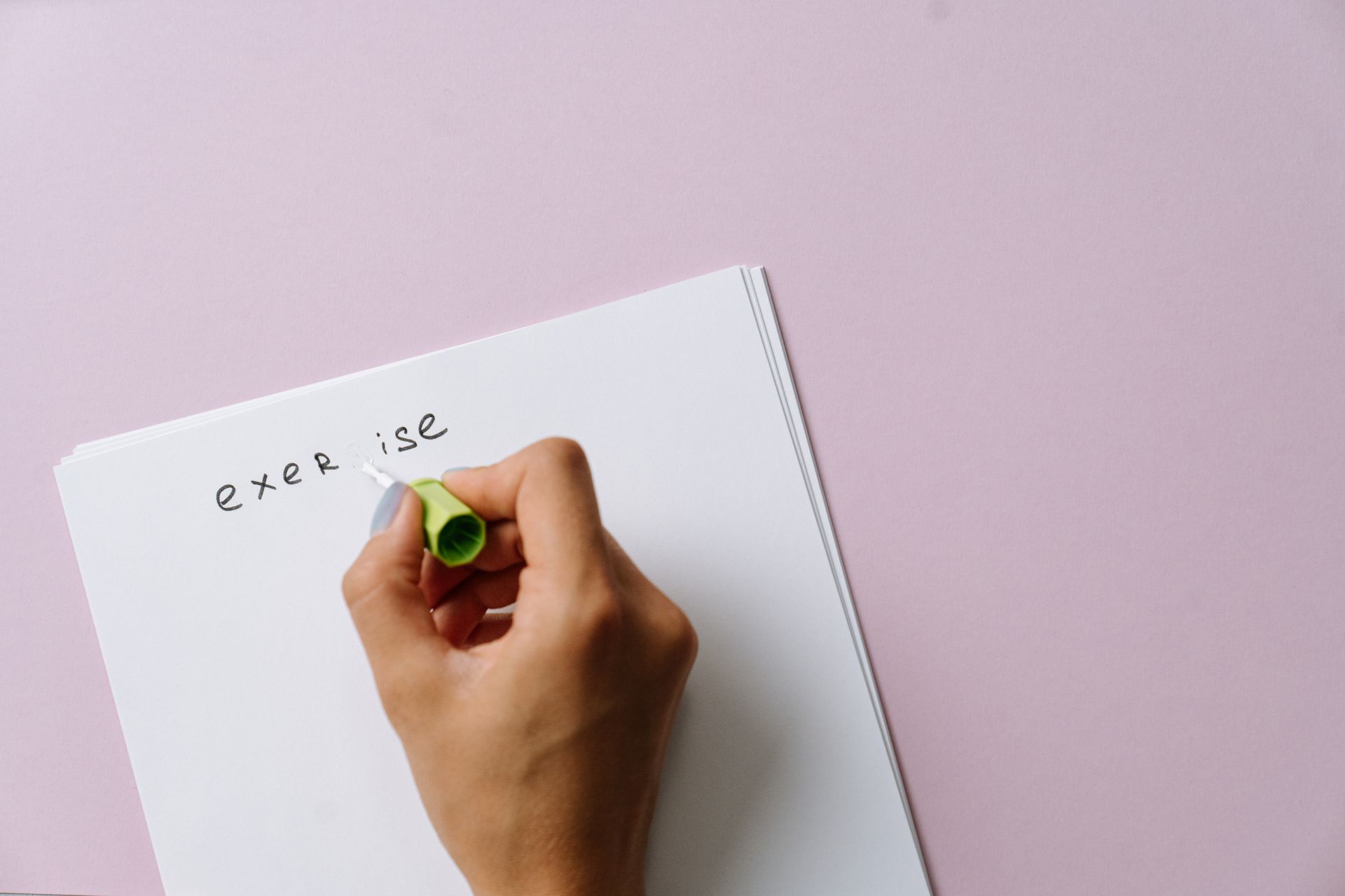 Close-up of Woman Using a White Corrector to Paint over a Letter