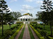 White and Yellow Gazebo Surrounded by Green Trees Under White Clouds and Blue Sky