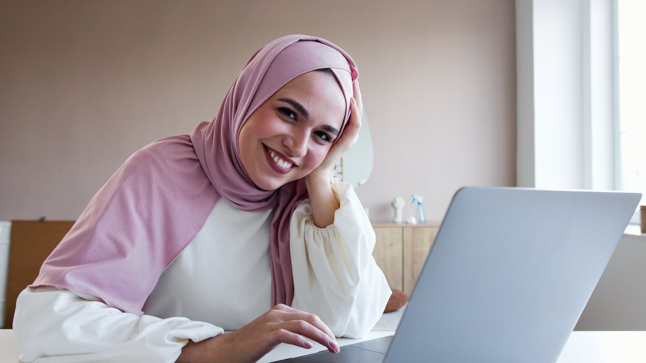 Free A Woman in White Long Sleeves and Pink Hijab Smiling Stock Photo