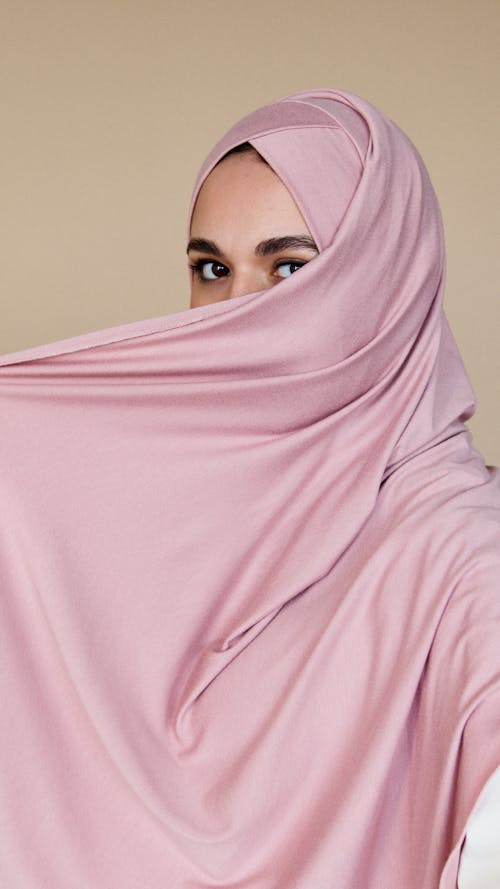 Free A Woman in Pink Hijab Covering Her Face Stock Photo