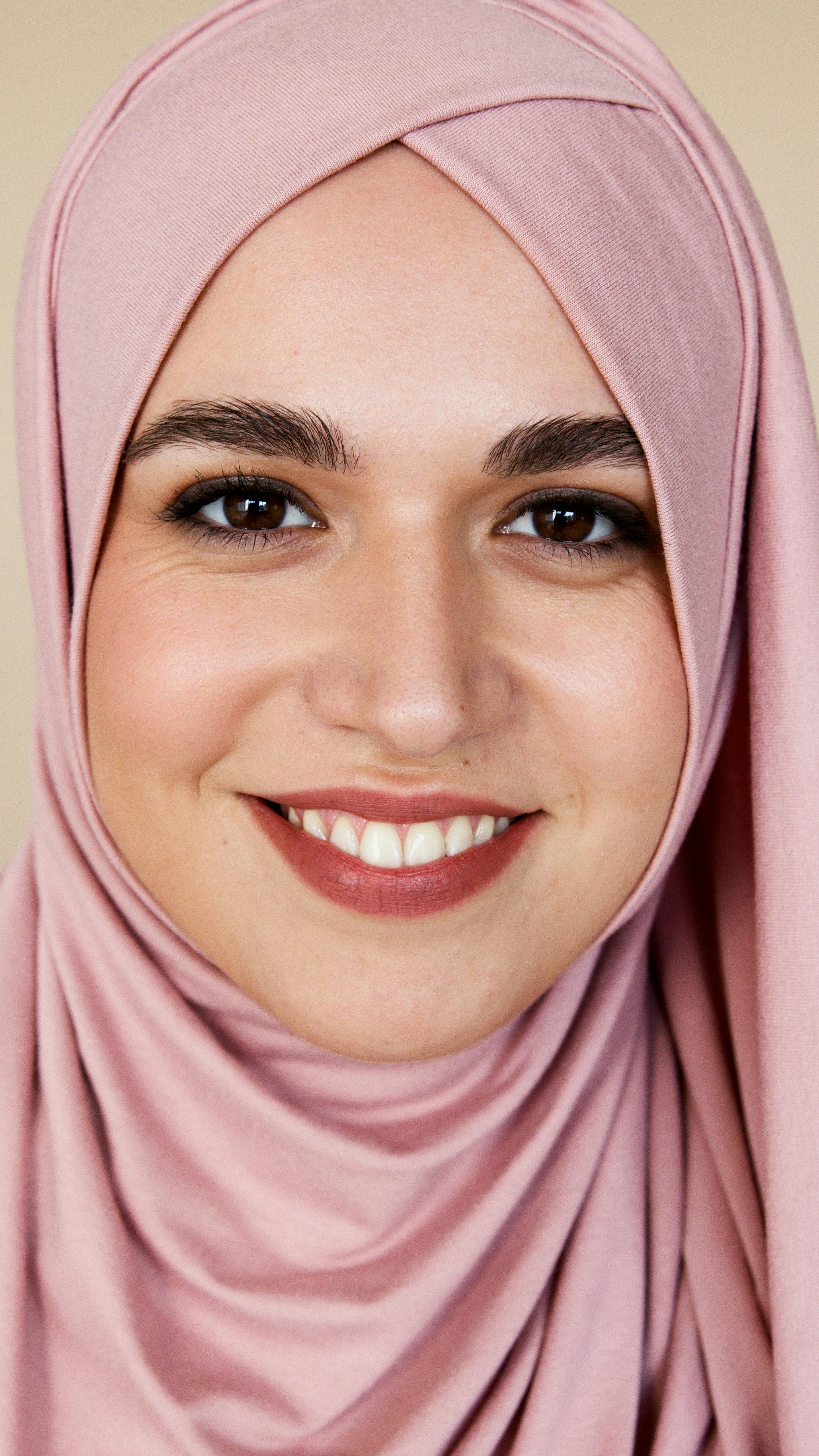 a woman in pink hijab smiling