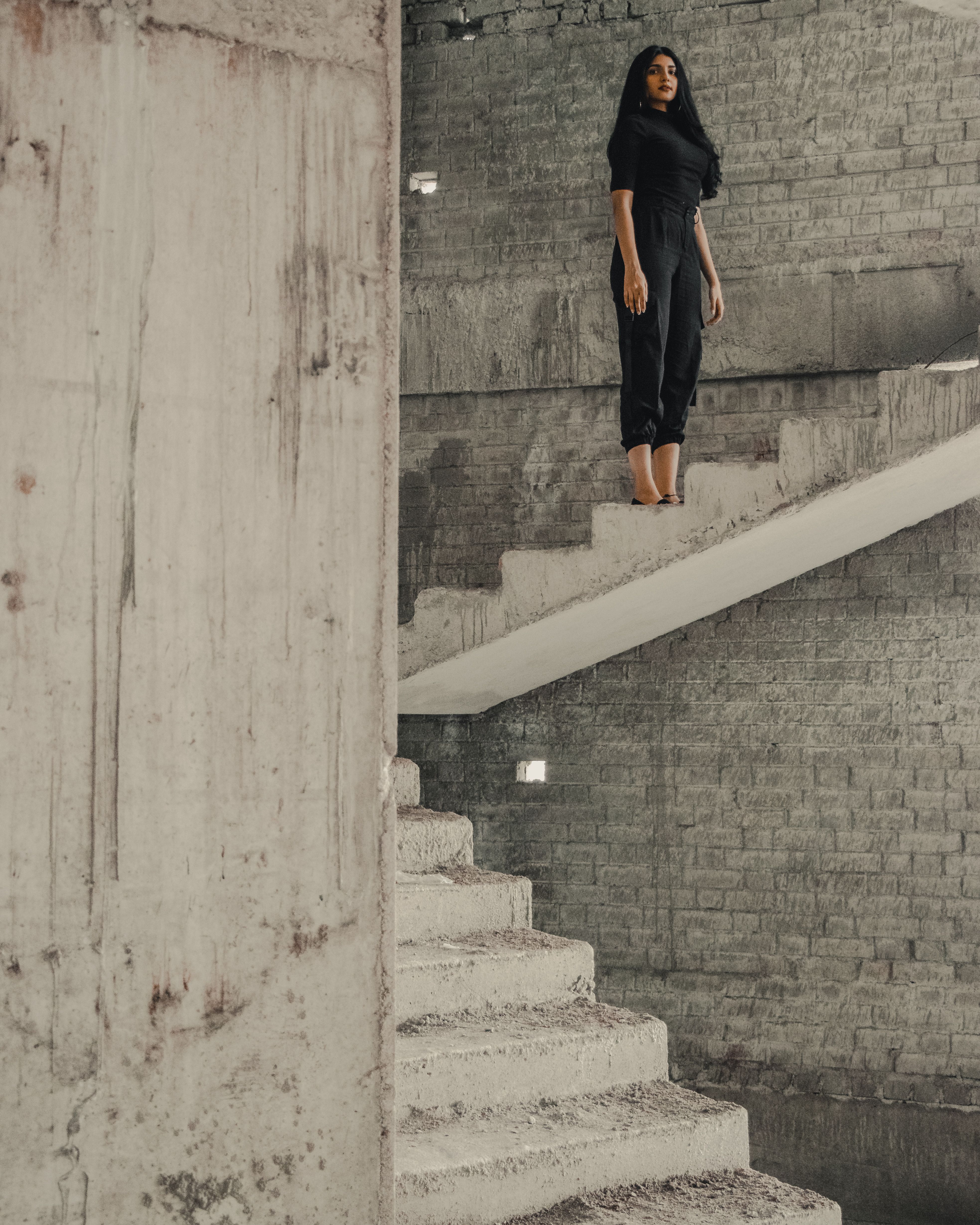 Rebar Cargo. Black technical cargo fit on brutalist concrete staircase