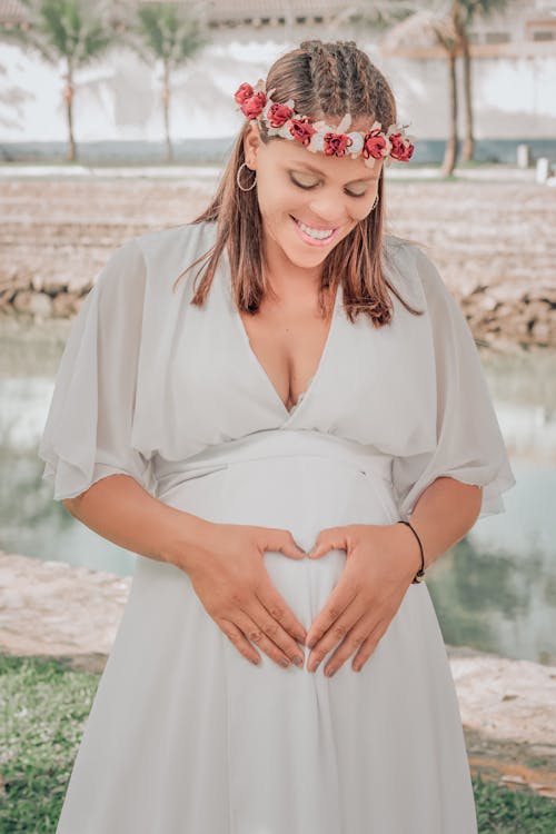 Free Pregnant Woman Holding Her Hands in a Heart Shape on Her Belly  Stock Photo
