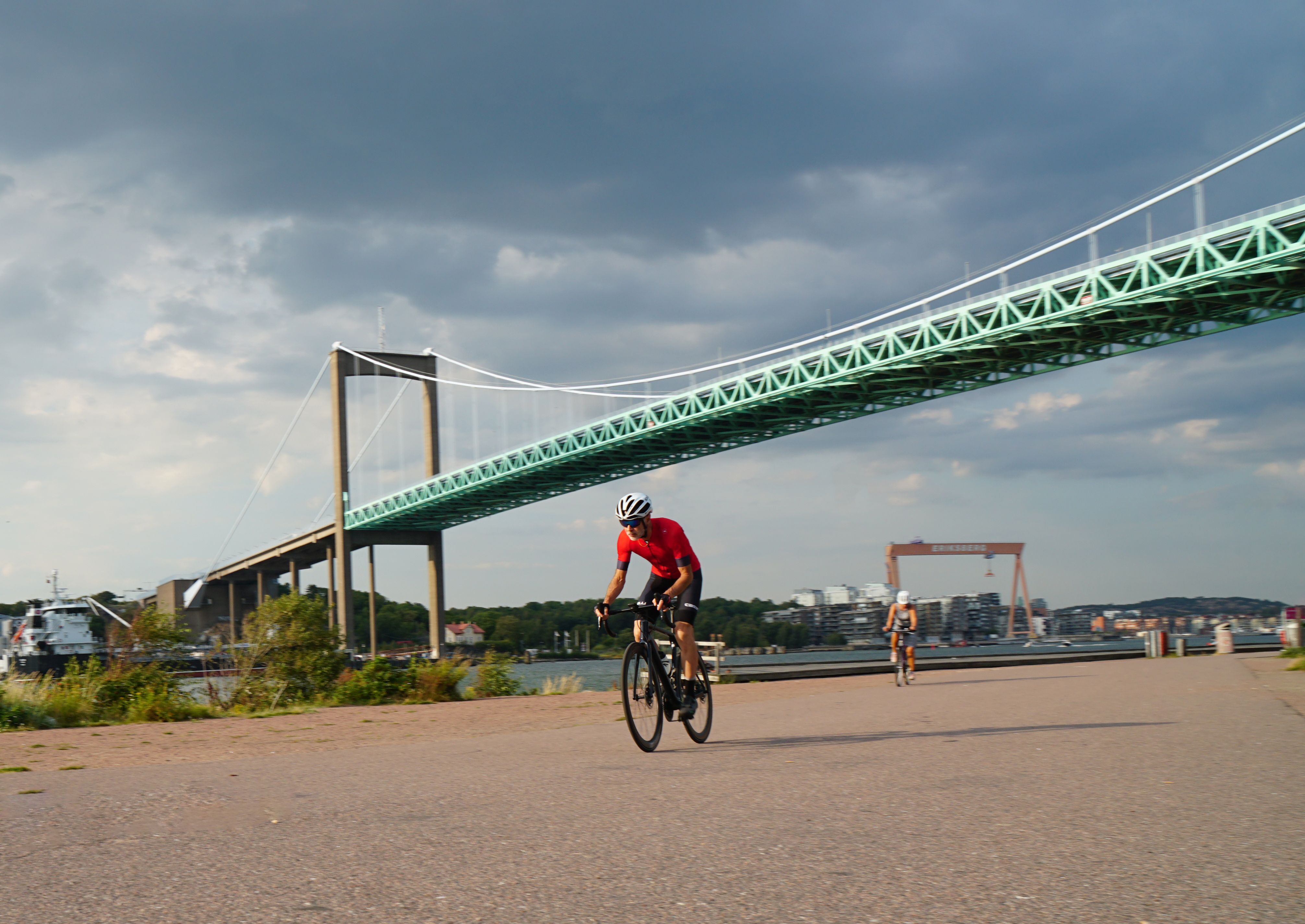 Cyclists enjoying a ride near the Älvsborg Bridge in Gothenburg, Sweden during a summer day.
