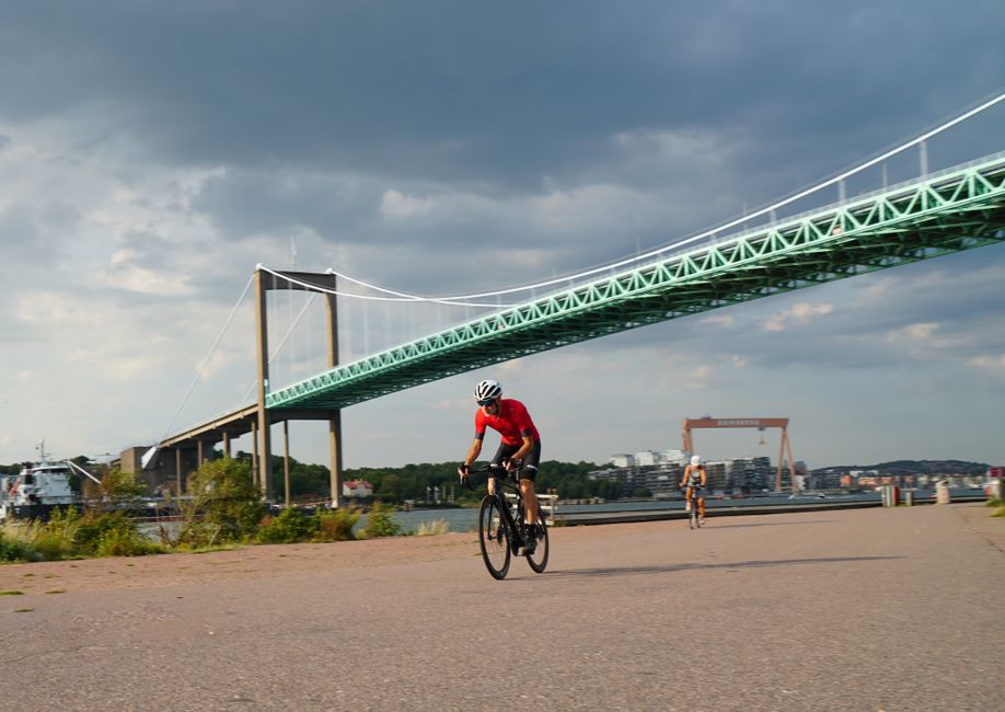 Cyclists enjoying a ride near the Älvsborg Bridge in Gothenburg, Sweden during a summer day.