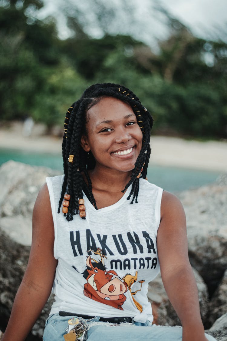 Smiling Black Woman In Stylish Apparel On Mount Near Lake