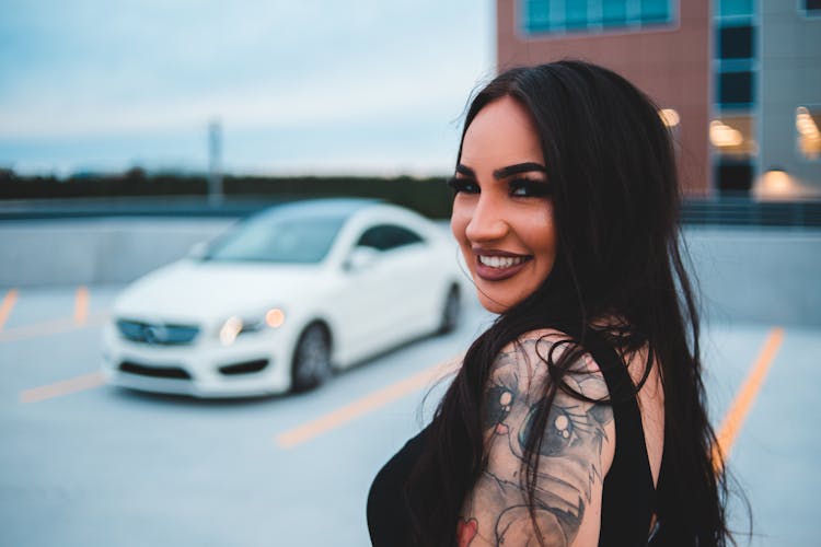 Positive Young Beautiful Woman By Sports Car In Daytime