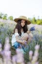 阳光明媚的田野里，一个戴着草帽的年轻女孩正在采摘熏衣草花