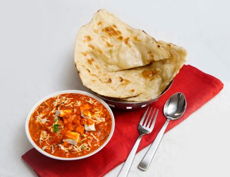 A vibrant and flavorful Indian paneer curry served with fresh naan bread, perfect for dinner.