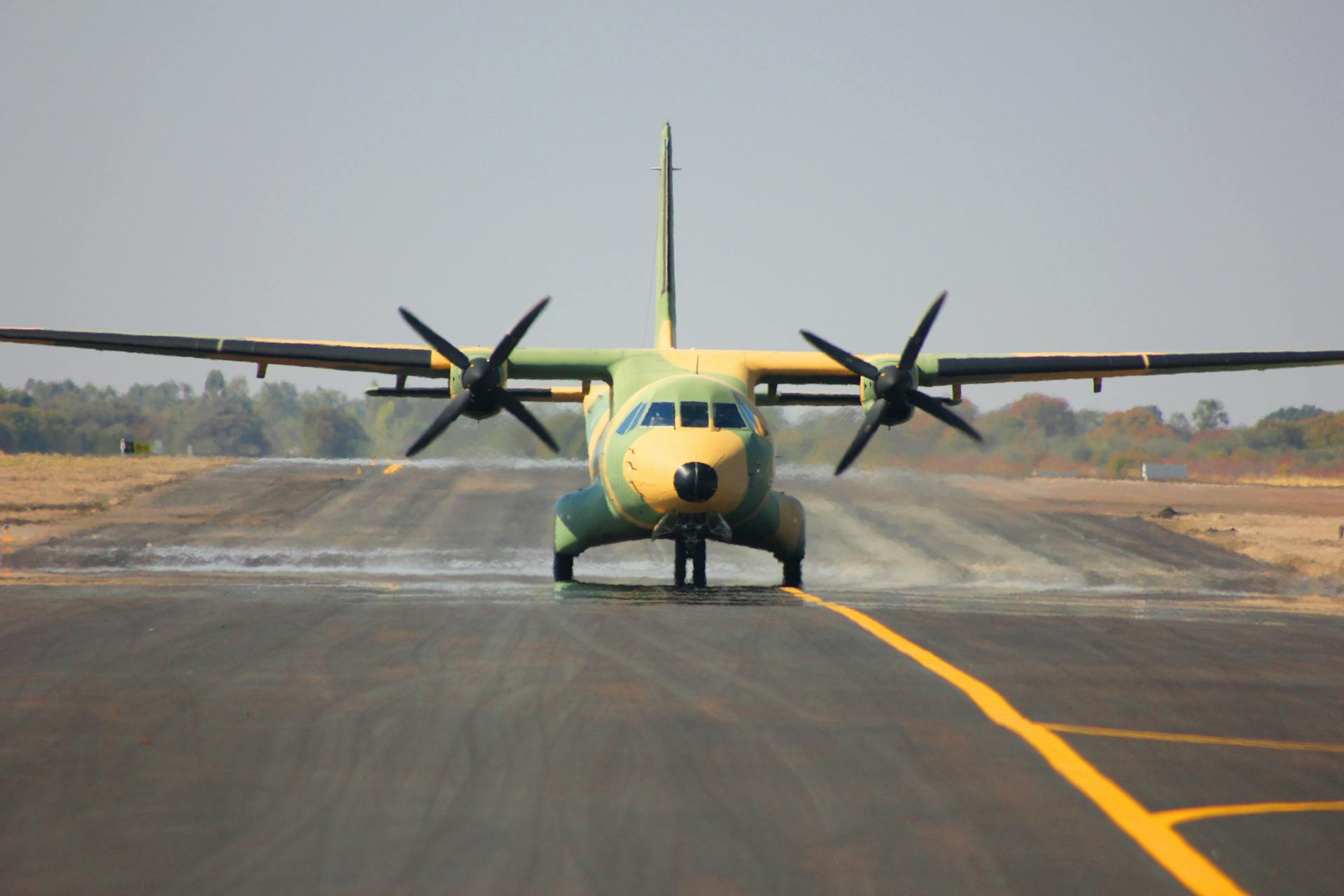 Camouflaged military aircraft on runway preparing for takeoff.