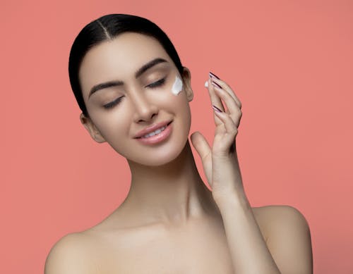 Free A Topless Woman Smiling With Cream on Her Face Stock Photo