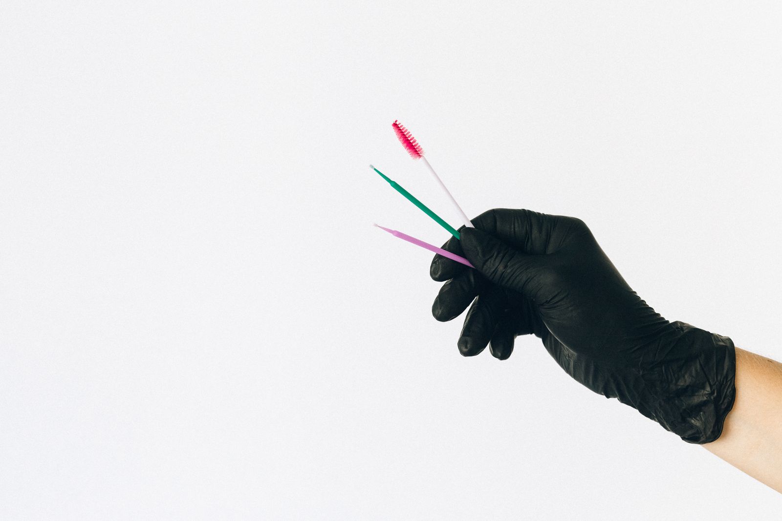 A close-up of someone cleaning makeup brushes under running water