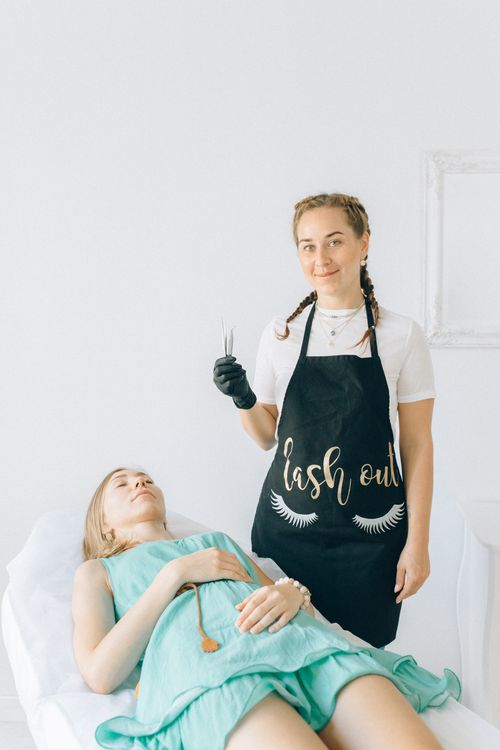 Free Beautician performing eyelash extensions in a bright, serene salon setting. Professional beauty service. Stock Photo