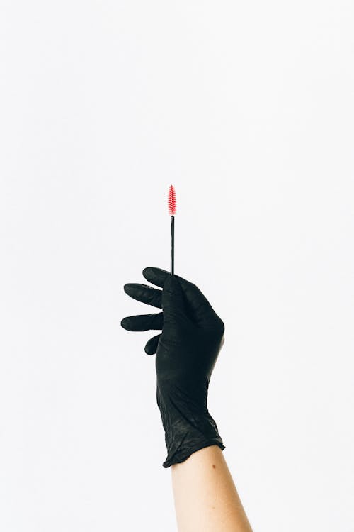 Person in Black Leather Gloves Holding Red Pen