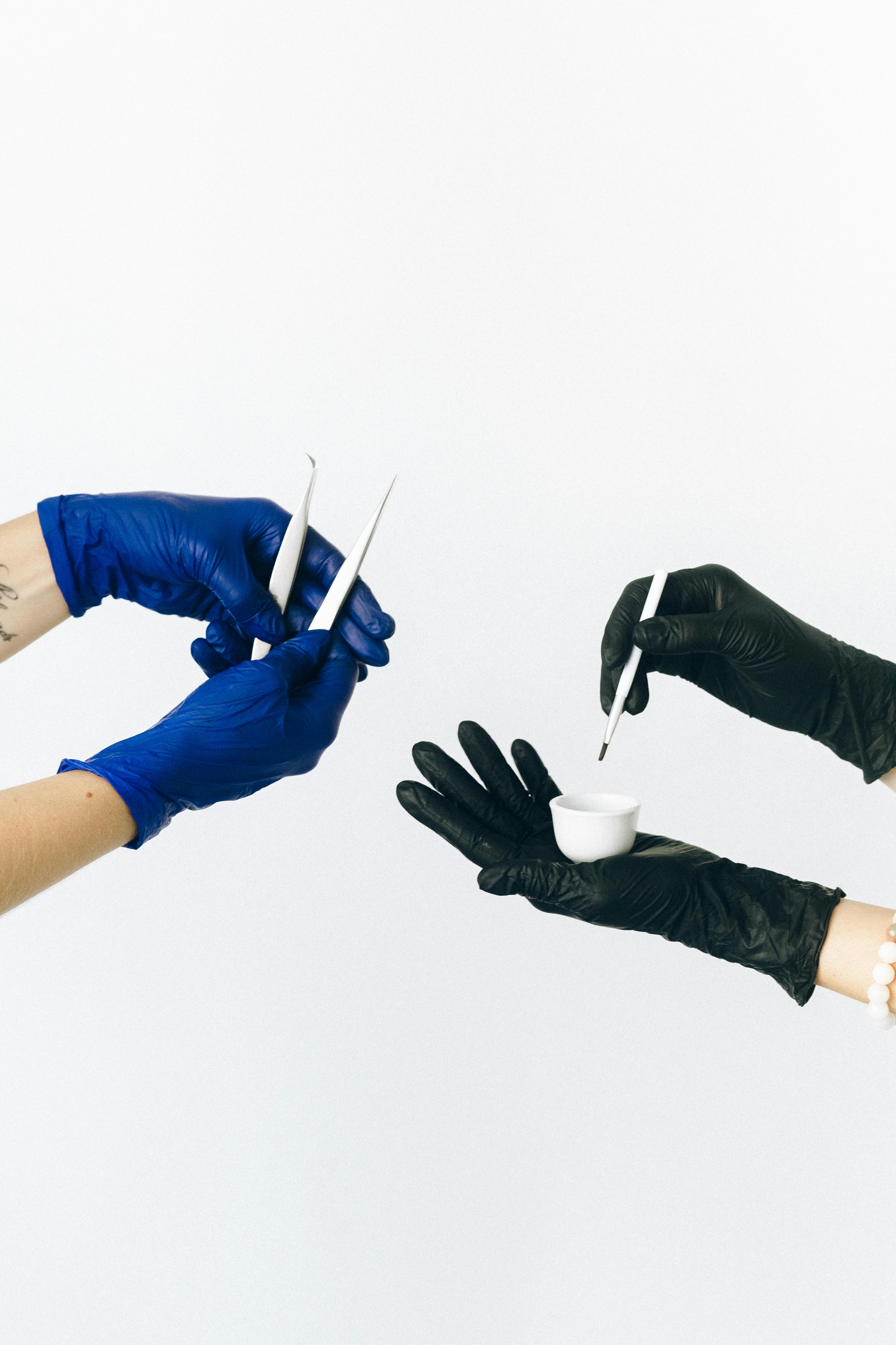 person in black leather gloves and blue denim jeans