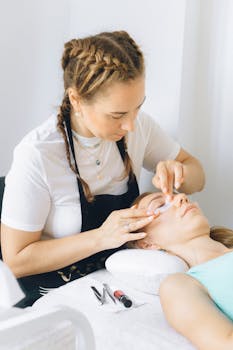 Beauty therapist applies eye treatment in spa setting. Relaxation and professionalism in focus.