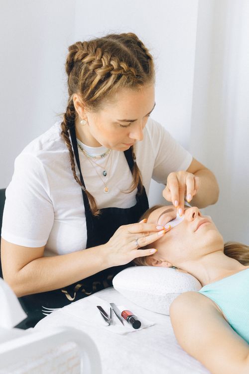 Free Beauty therapist applies eye treatment in spa setting. Relaxation and professionalism in focus. Stock Photo