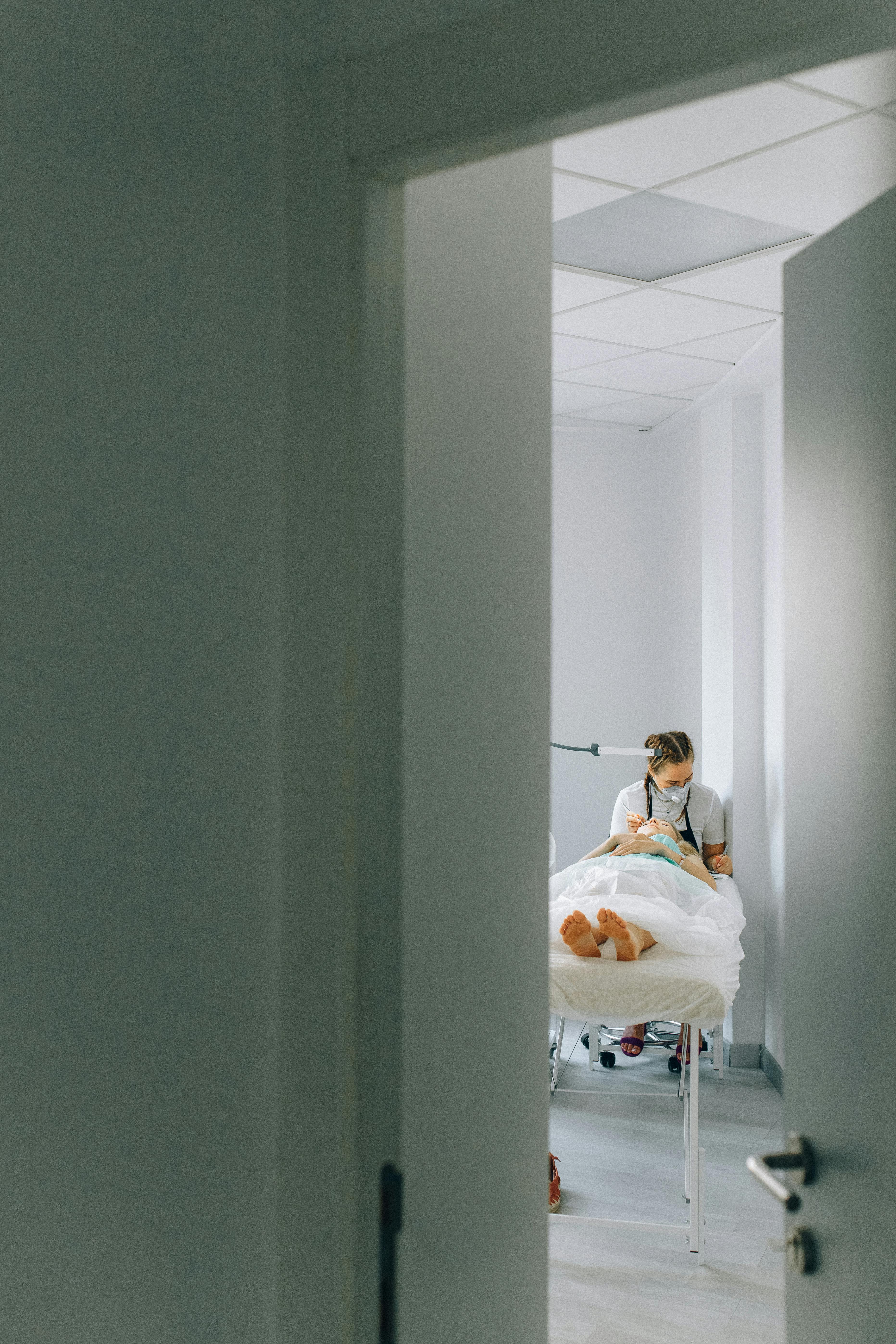a beautician attending to a female client in a room