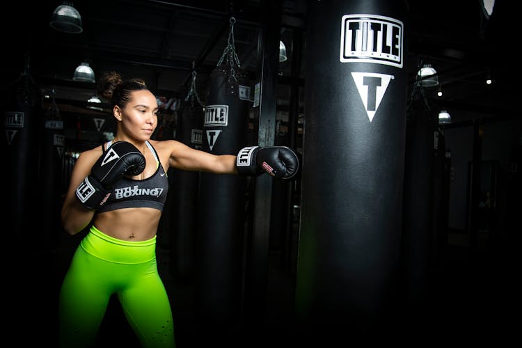 Athletic Woman In Sportswear Boxing Punching Bag