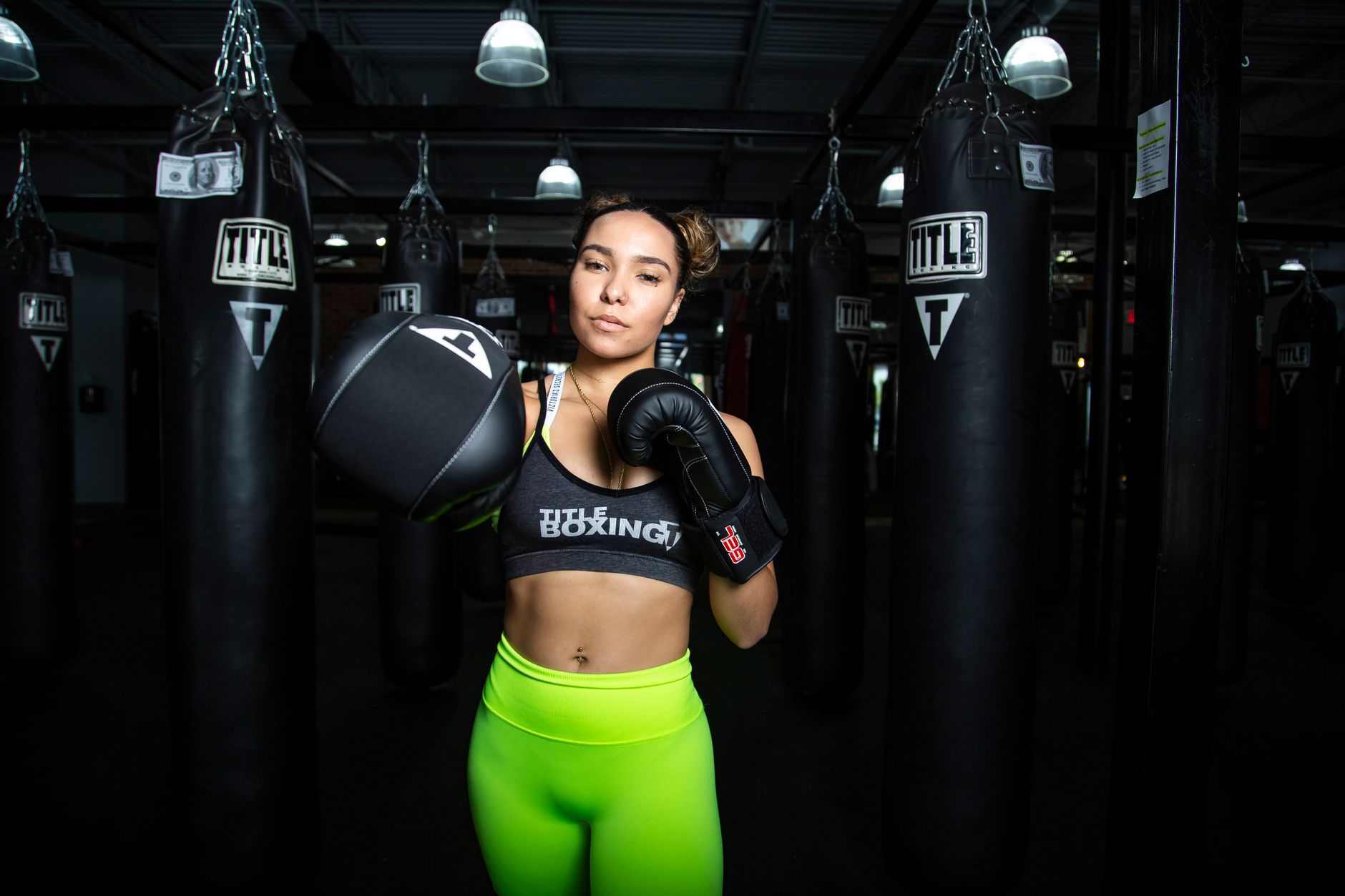 A focused female athlete practicing boxing in a gym, enhancing strength and fitness.