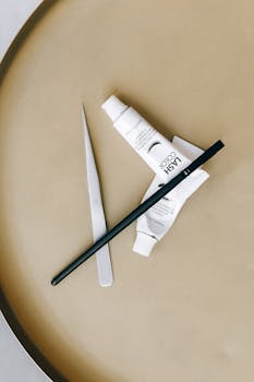 米色表面的时尚扁平睫毛色调和工具，是美容概念的理想选择