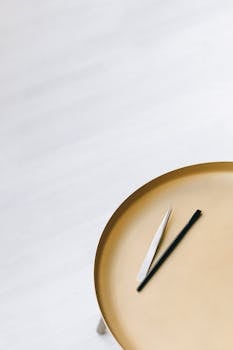 金属托盘造型时尚，上面摆放着极简风格的睫毛延长工具，非常适合美容和时尚主题