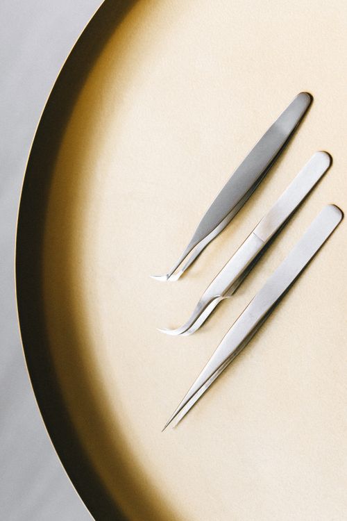 Free High angle view of three stainless steel tweezers on a flat circular surface. Stock Photo