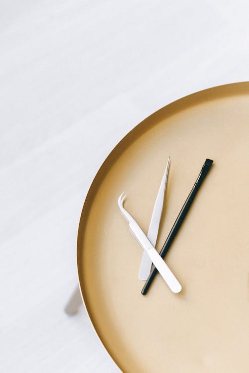 Tweezers on Brown Plate