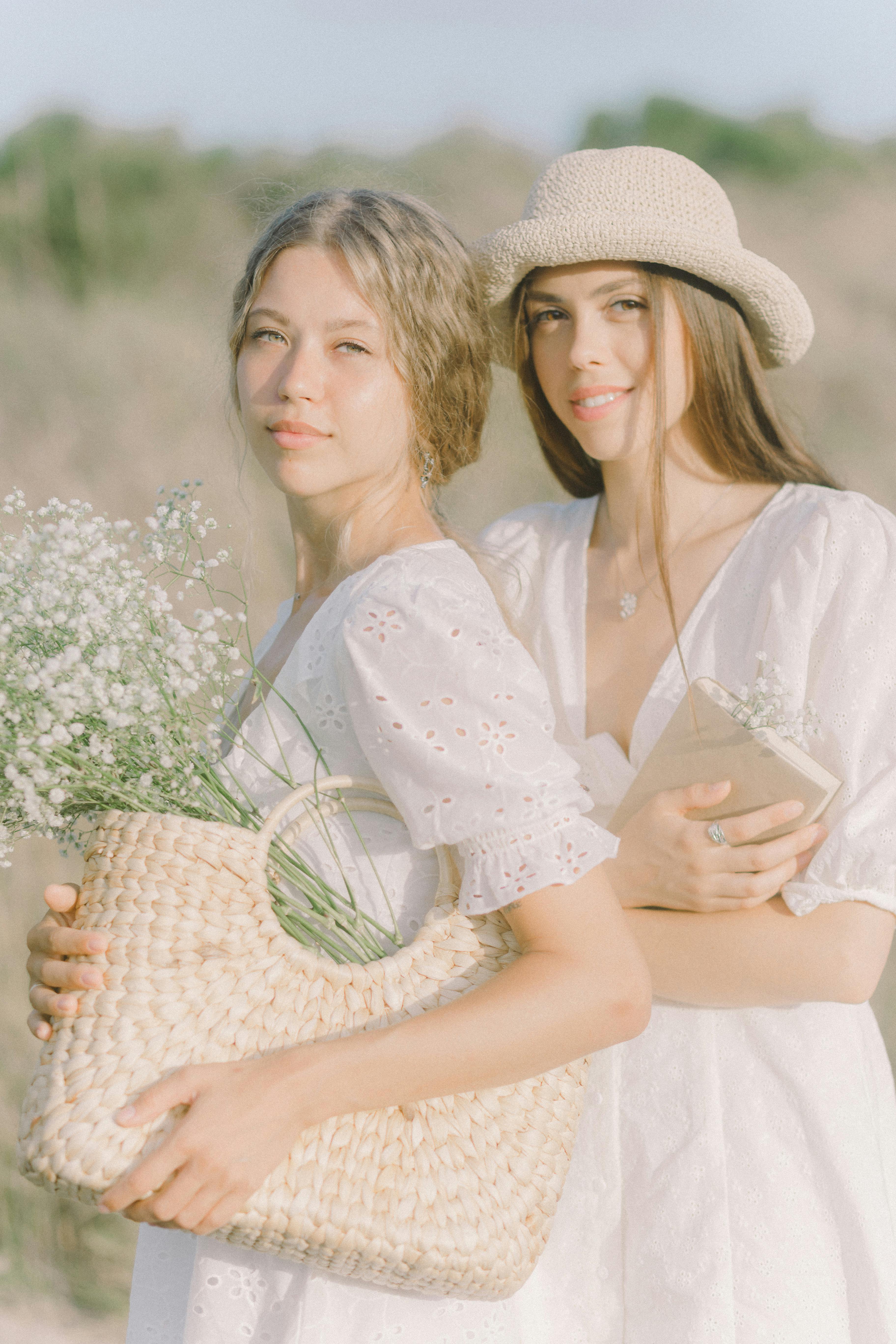 两个女人手里拿着鲜花和编织篮子，在阳光下微笑着