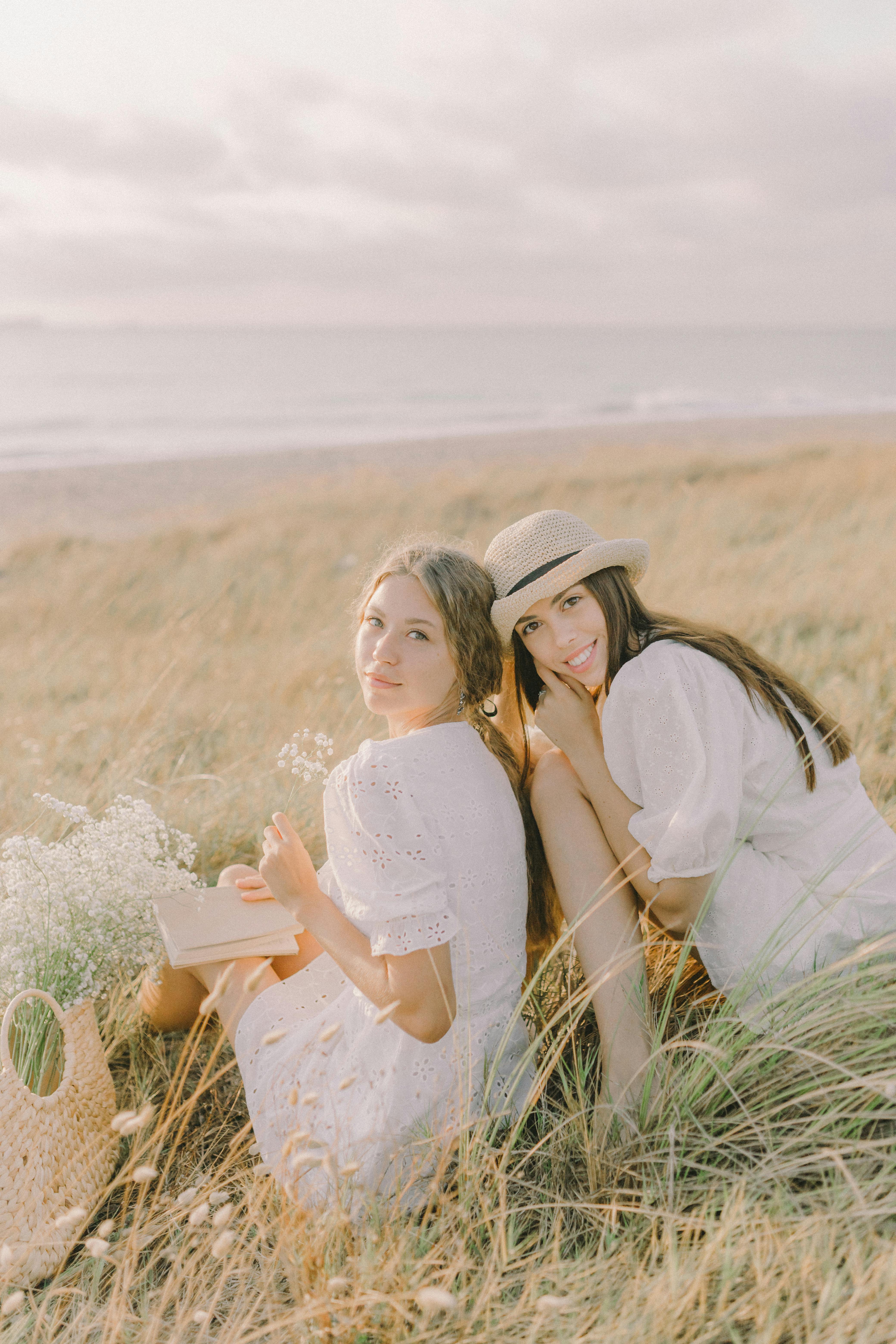 women sitting on the grass field